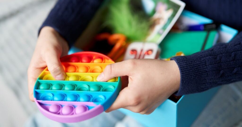 Ein Kind hält ein Fidgettoy in den Händen.