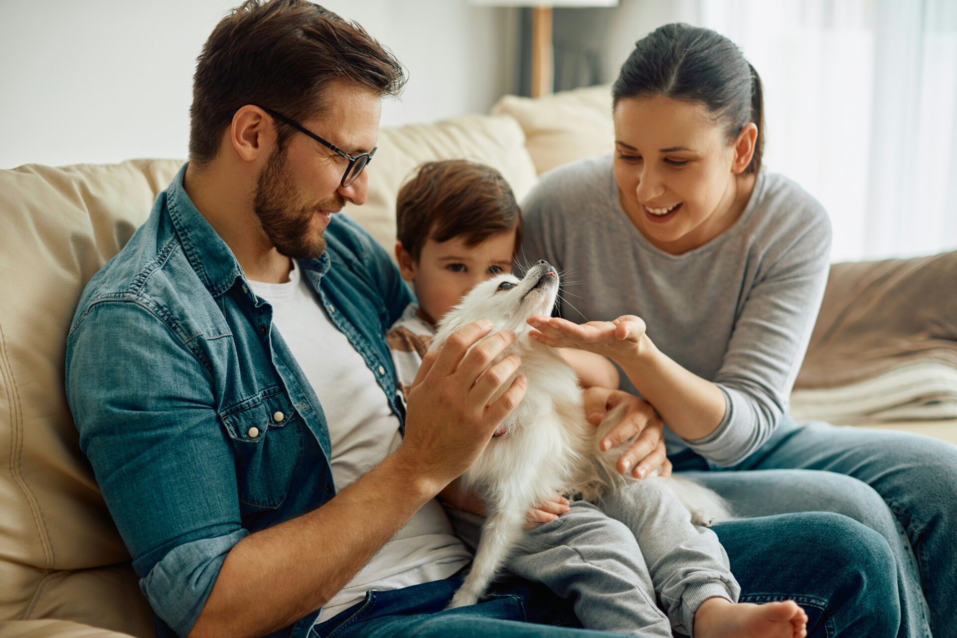 Familie mit Kind und Hund auf dem Sofa