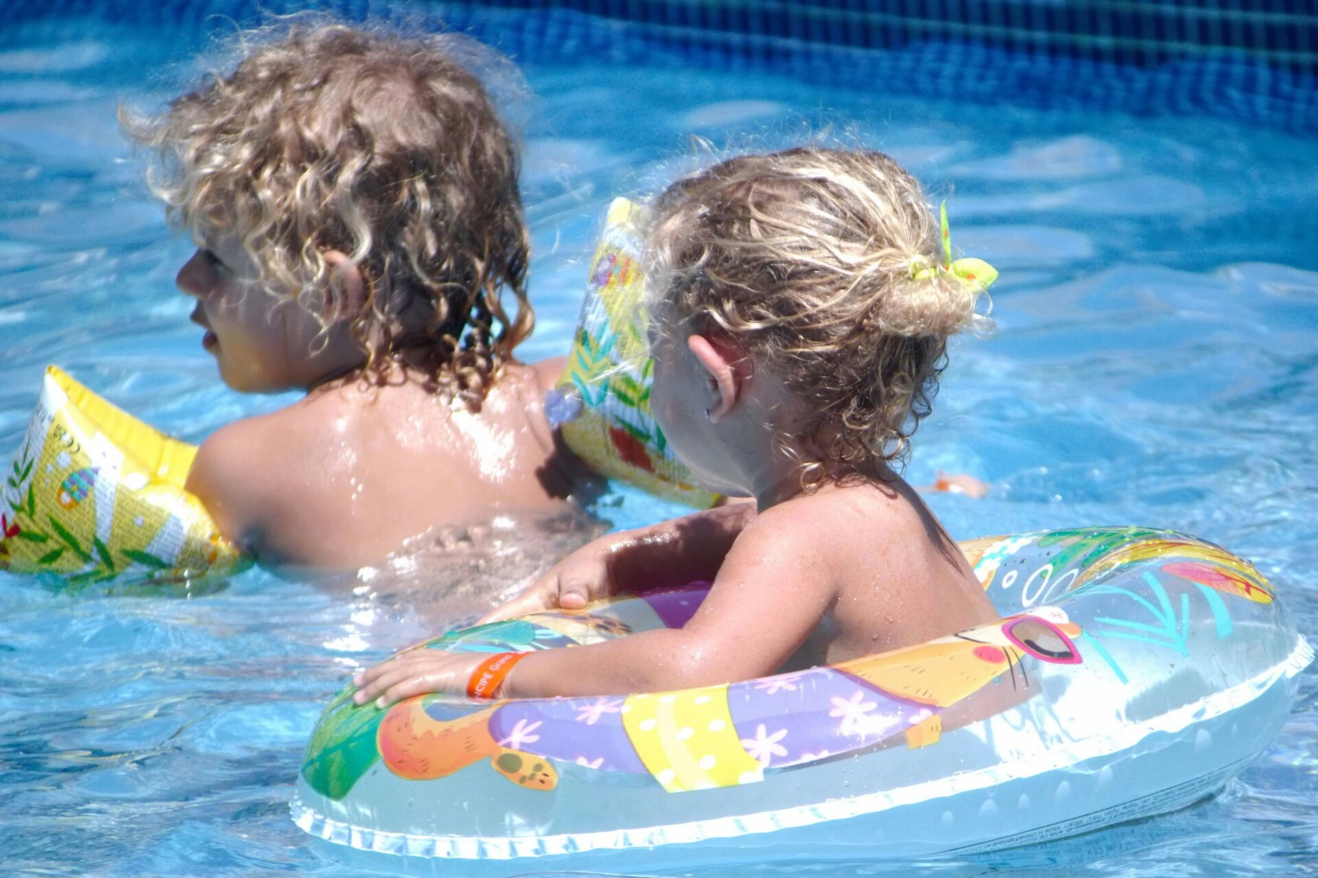 Kinder mit Schwimmhilfen im Wasser