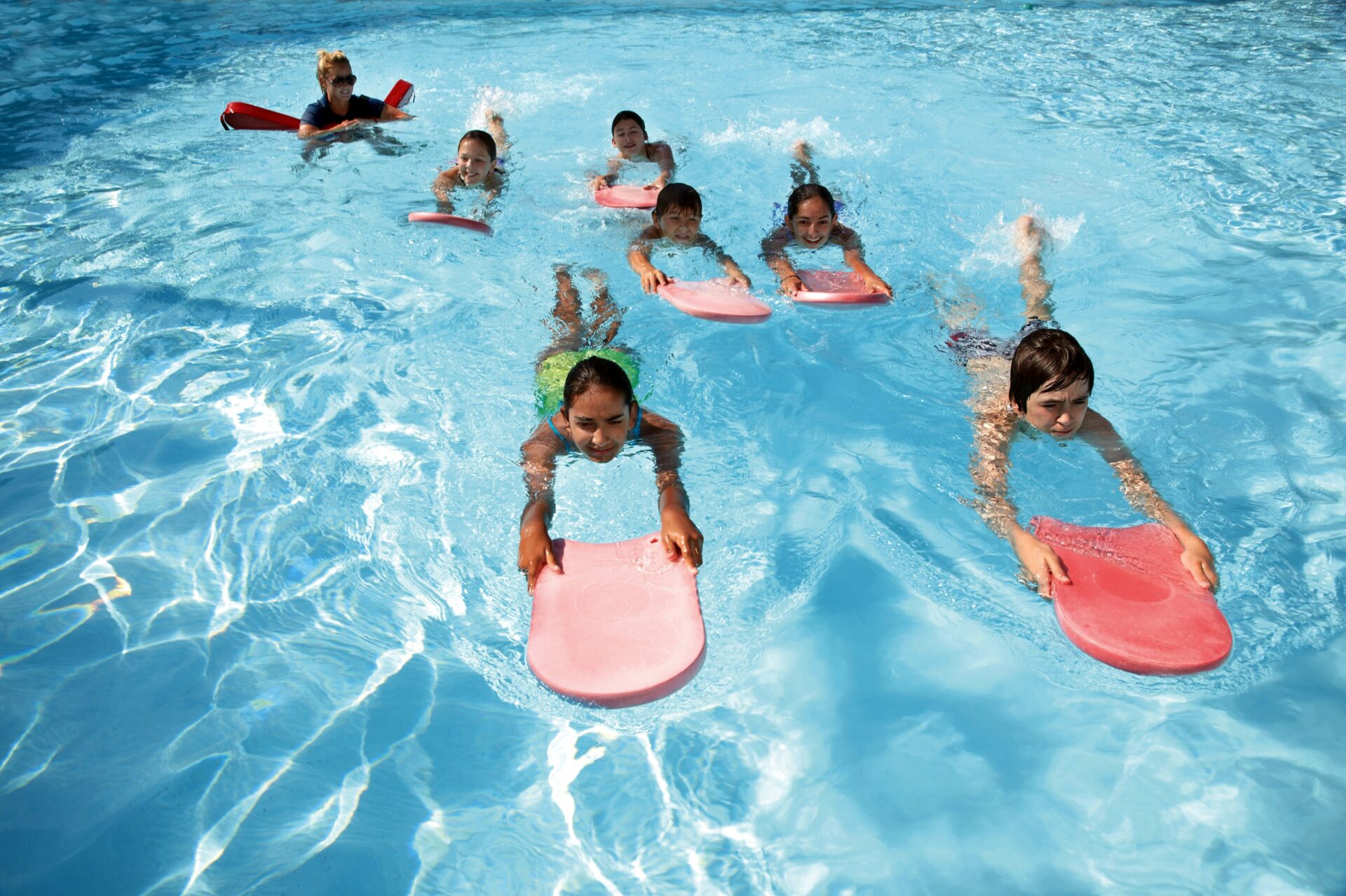 Kinder üben Schwimmen in einem Schwimmkurs