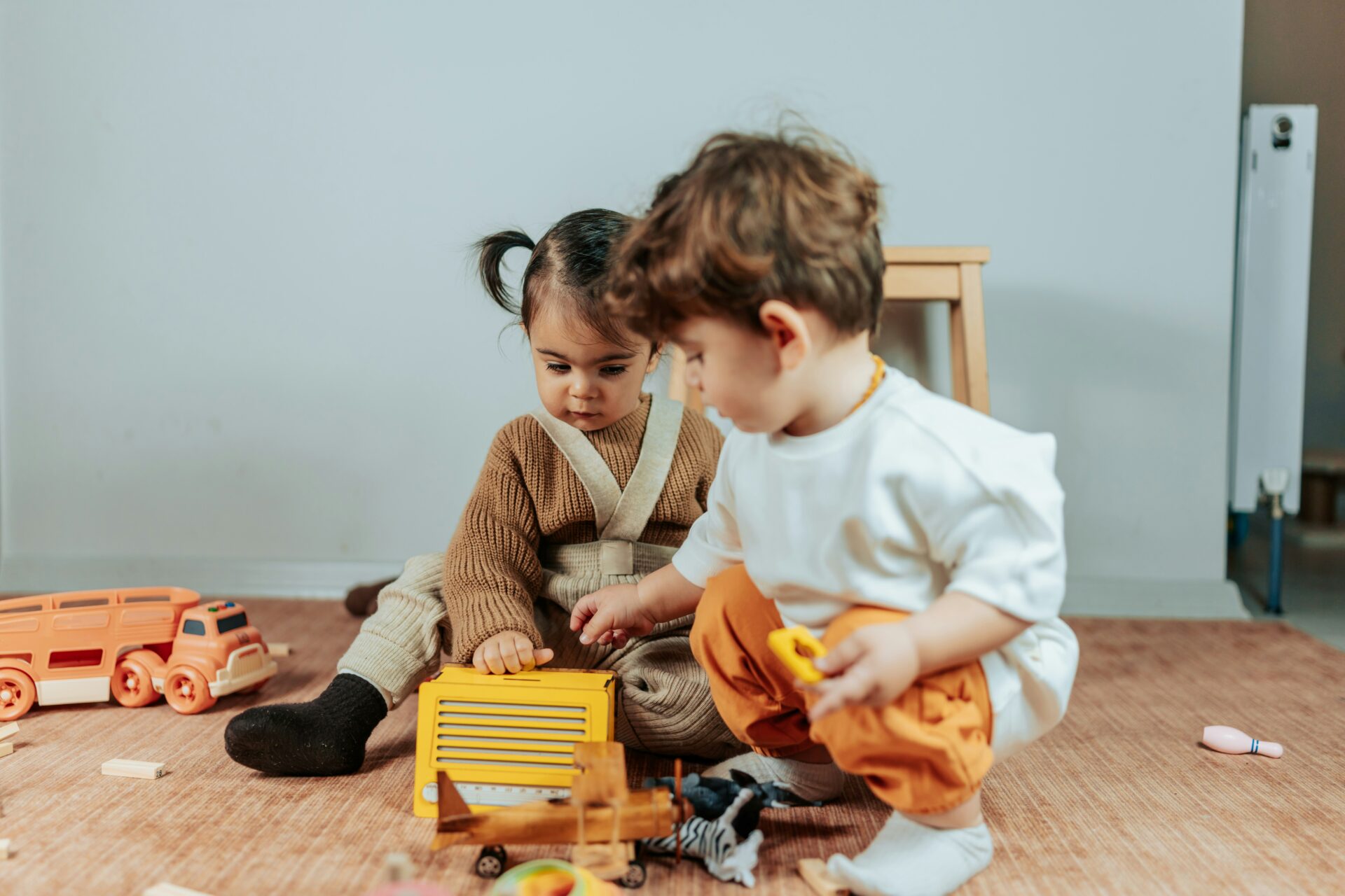 geschwisterstreit ferien, zwei Geschwister spielen gemeinsam mit Spielzeug