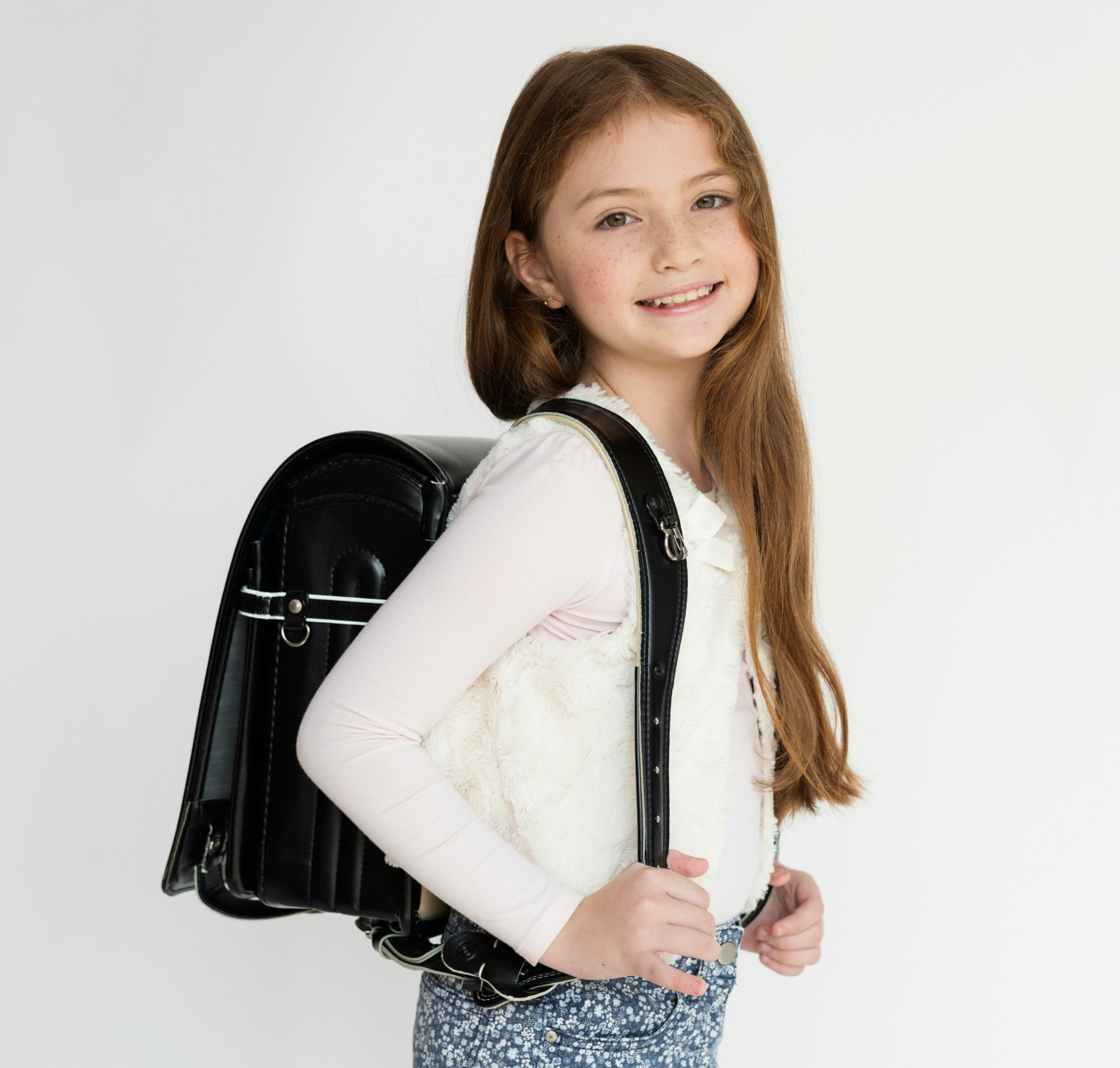 einschulung loslassen, Mädchen mit Schulthek vor dem ersten Schultag
