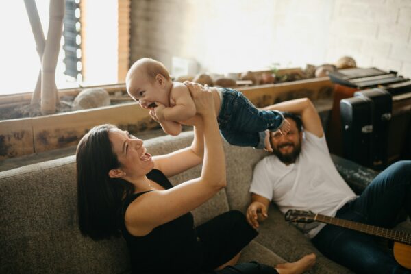 Mutter und Vater verbringen zu Hause Zeit mit ihrem Baby