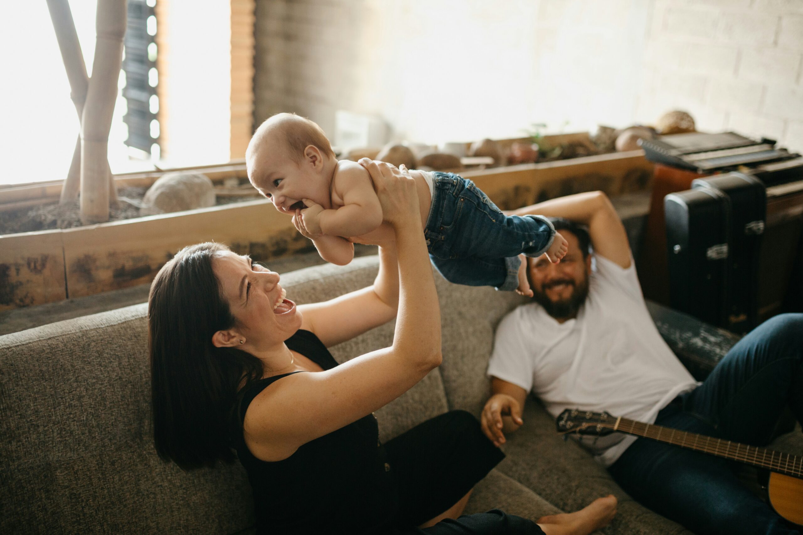 Mutter und Vater verbringen zu Hause Zeit mit ihrem Baby