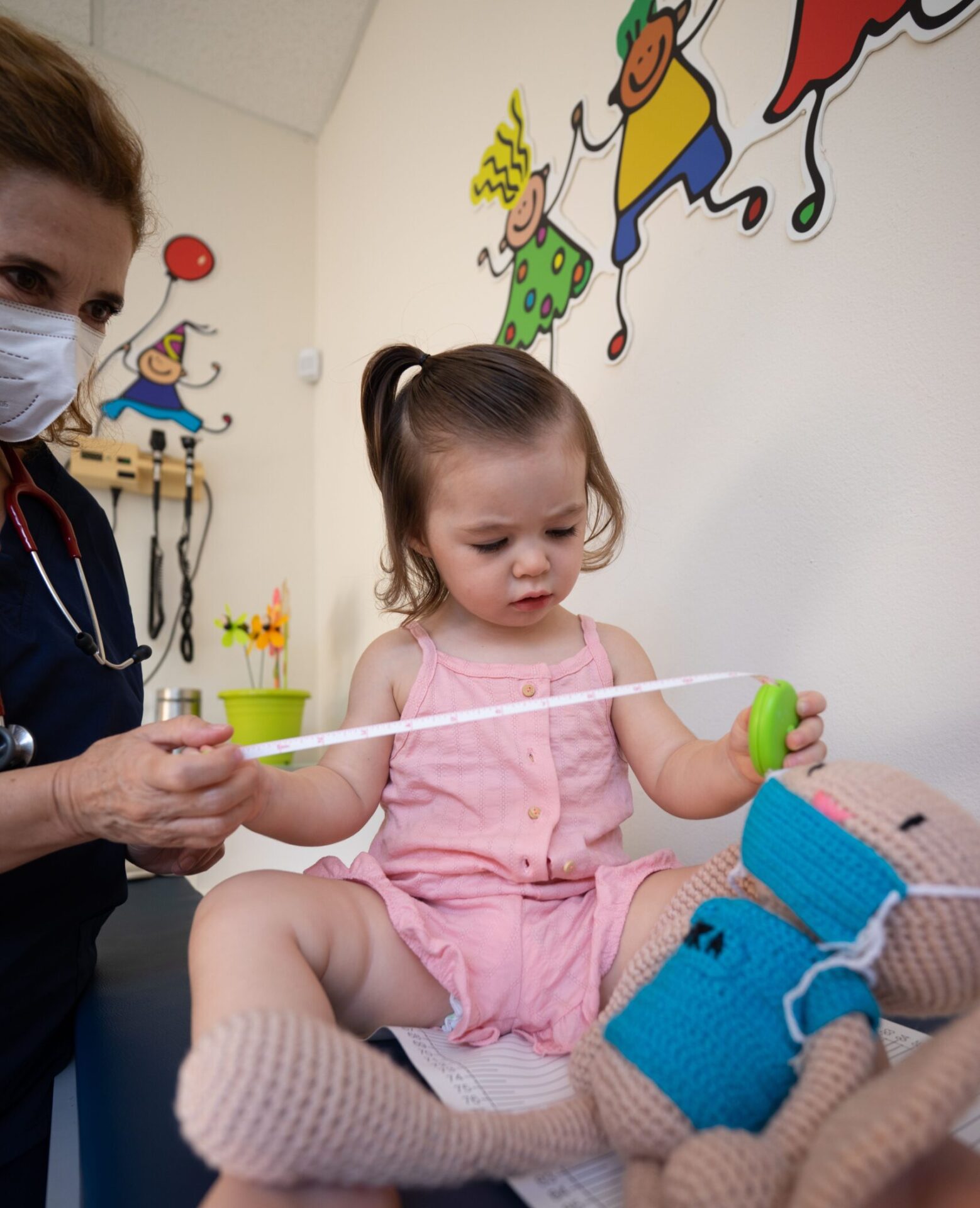 Kind mit Massband bei einer Untersuchung in einer Kinderarztpraxis