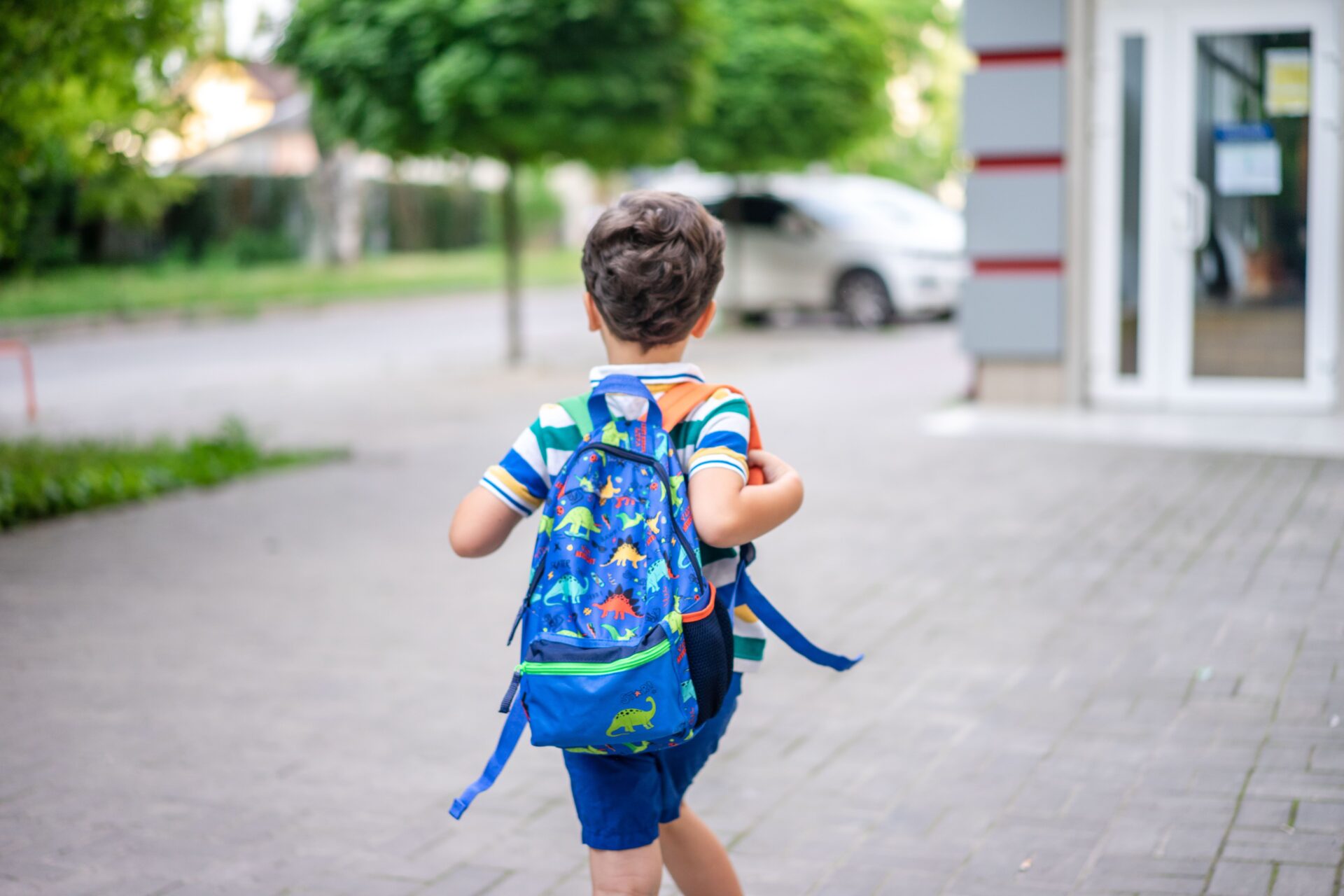 Kind mit Rucksack auf dem Weg zur Schule