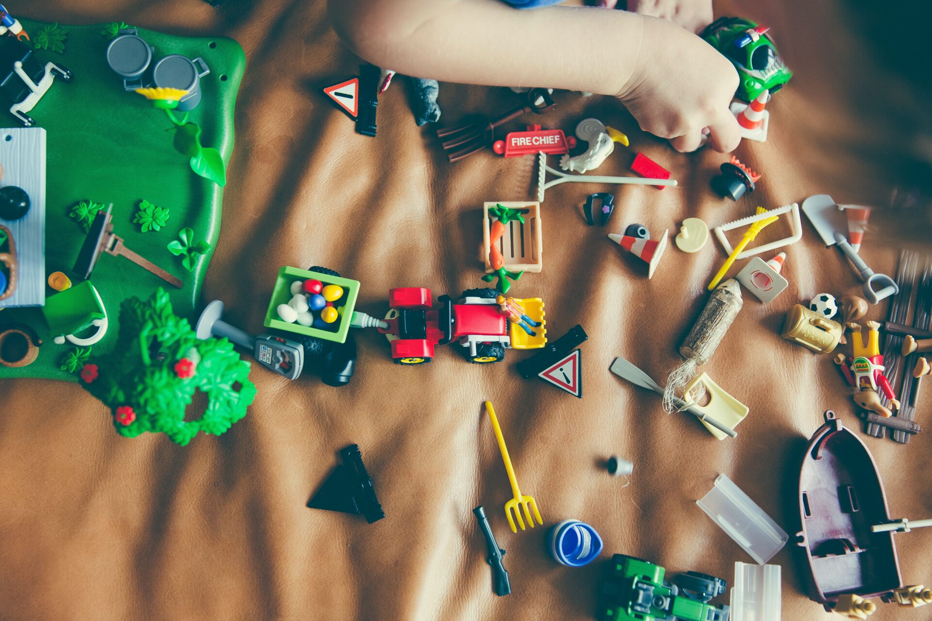 Zahlreiche kleine Spielfiguren und Spielzeugteile liegen auf einer Spielfläche