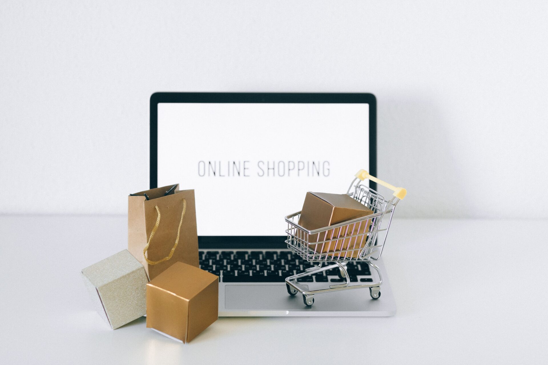 Laptop mit Online-Shopping-Anzeige, Einkaufswagen und Versandpaketen